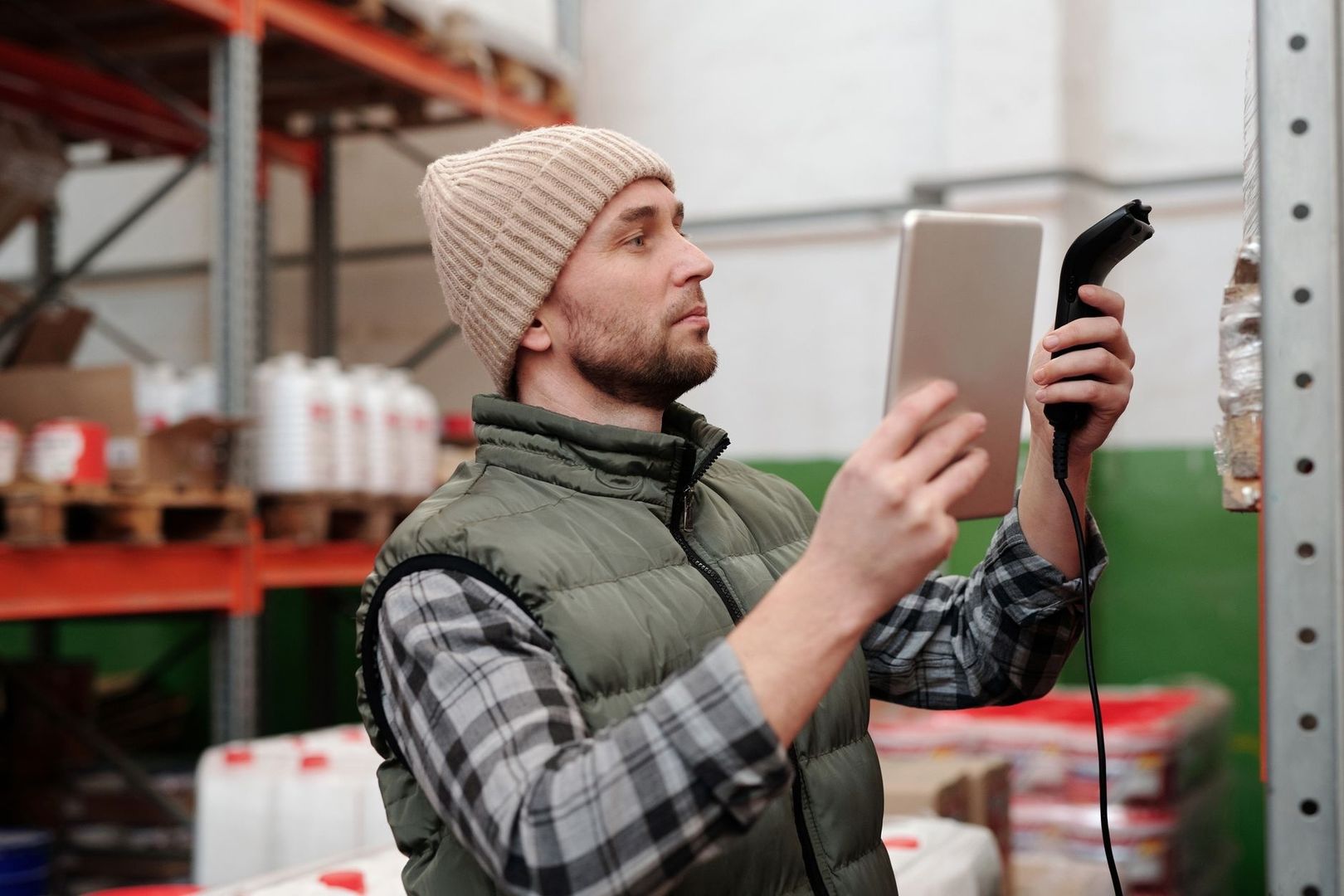 Mitarbeiter erfasst Waren im Lager mit Tablet und Handscanner